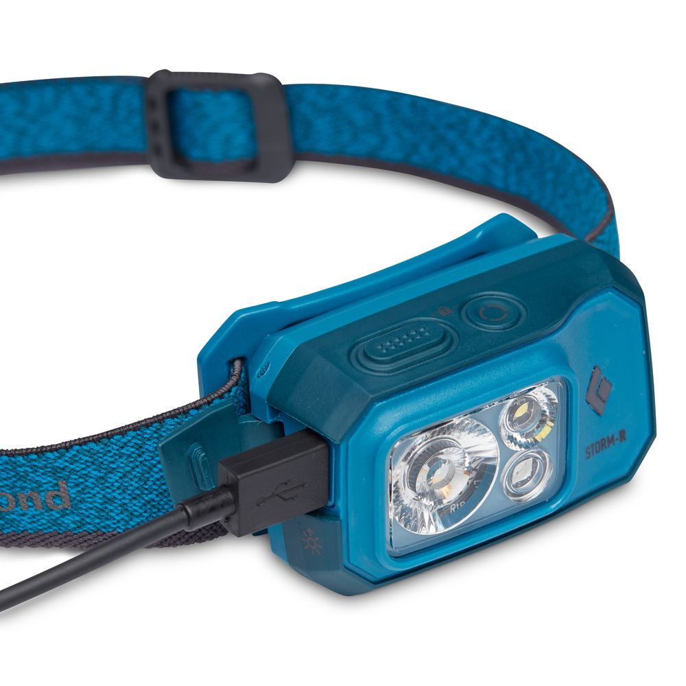 The Black Diamond Storm Rechargeable Headlamp, in blue, offers 500 lumens of brightness and features an adjustable strap. It is rechargeable via USB cable for convenience.