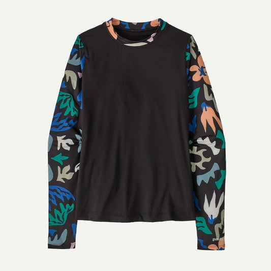 The Patagonia W's Swell Seeker Rashguard features a solid black front and back with long sleeves adorned in a colorful abstract floral pattern.