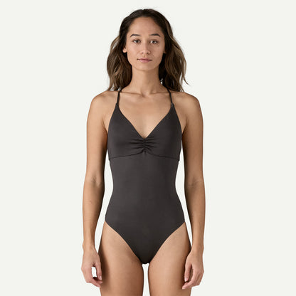 Wearing the Cross Shore One Piece by Patagonia, a person stands against a plain light background.