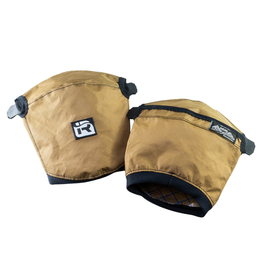 The Immersion Research Nanowave Handwarmer Pogies are lightweight, brown handwarmers with black trim and Velcro straps, designed for warmth and comfort, featuring small brand logos on the front.