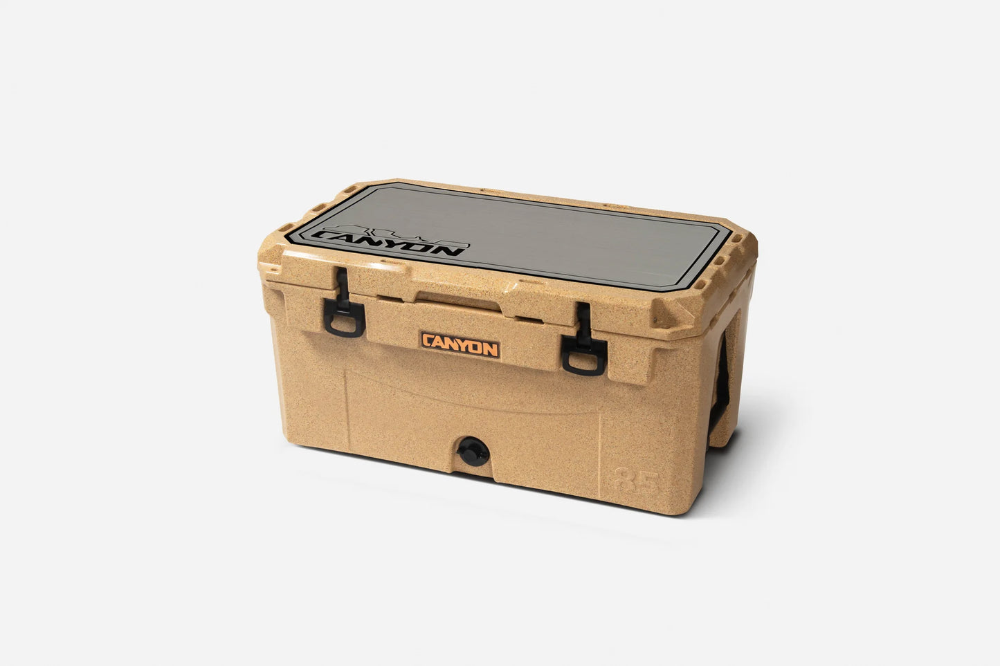 Tan Canyon Coolers cooler with black latches, orange Canyon Coolers logo, and flat lid, featuring an EVA foam Cooler Traction Pad for grip, displayed on a plain white background.