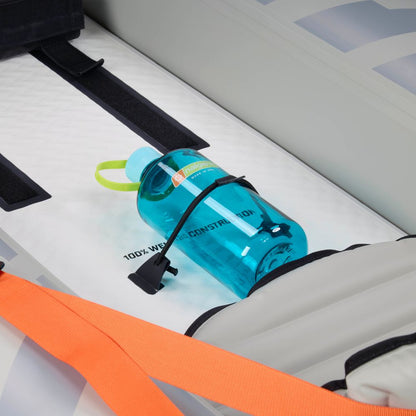 A blue water bottle with a black strap sits inside an NRS Akamai 110 Inflatable Kayak, which features PVC-free nylon, an orange strap, and a grey seat.