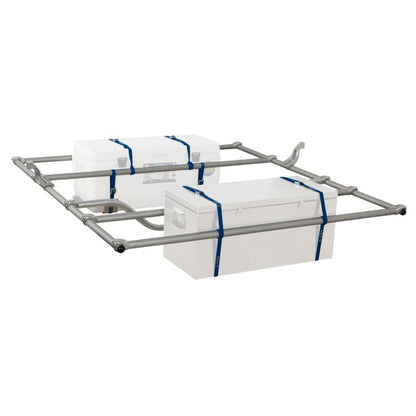 The NRS Compact Outfitter Raft Frame features a metal frame with two white boxes secured by blue straps, perfect for whitewater expeditions. The adjustable cooler mounts keep everything secure.