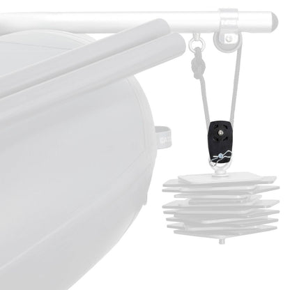 A black NRS Anchor Pulley is mounted on a rope, suspending stacked square metal plates under a rail on a boat to deliver mechanical advantage.