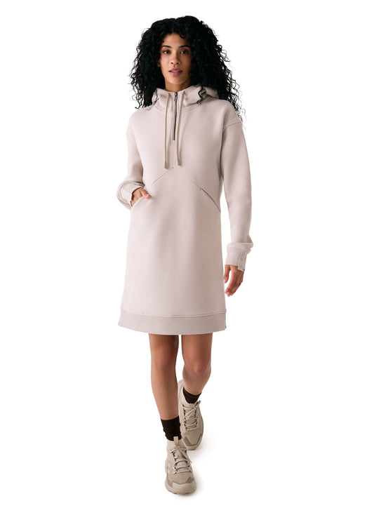 A woman in the Lole Yonder Hoodie Dress, paired with brown socks and beige sneakers, stands against a white background.