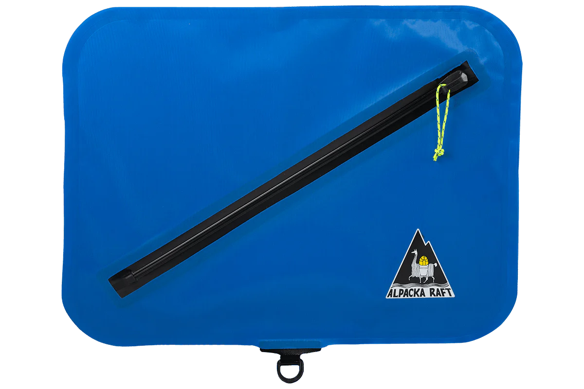 A waterproof Lap Bag in blue with a black handle by Alpacka.
