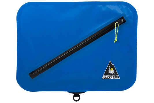 A waterproof Lap Bag in blue with a black handle by Alpacka.