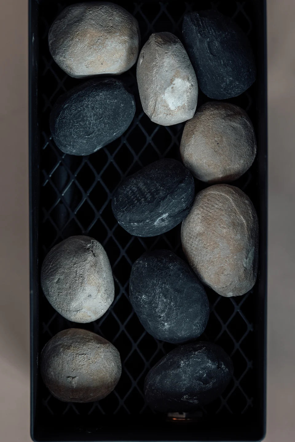 A black metal tray filled with rocks on a table, complementing the LavaBox VolCanNo Tacana Combo aesthetic.