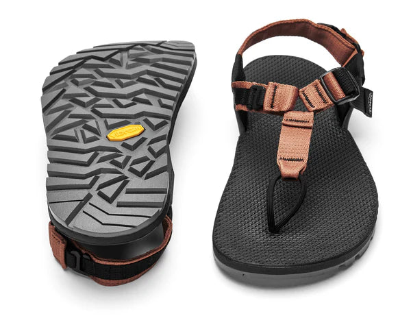 The Bedrock Carin 3D Pro II hiking sandals in black and tan feature a secure fit and textured soles; one sandal is shown from the bottom to highlight the grip, while the other displays the top view.