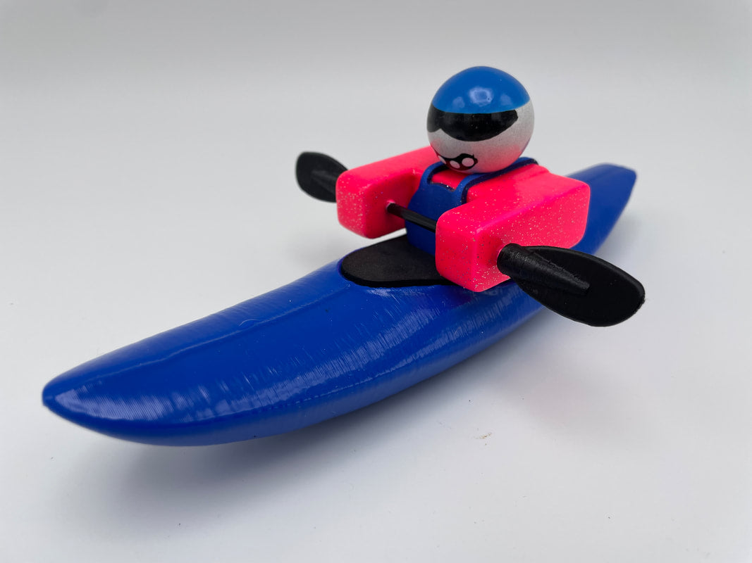 The Foamie Mini Creeker, from the Foamie Friends collection, is shown kayaking in a blue kayak while wearing a bright pink life vest and a blue helmet. Perfect for river play, this vibrant adventurer is an exciting addition to your collection.