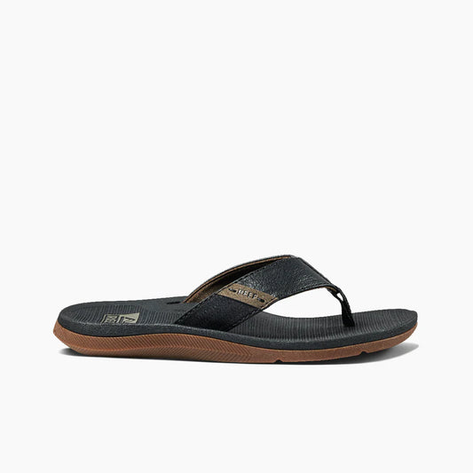 The REEF SANTA ANA sandal by REEF features a black and brown design, textured sole, high arch support, and a wide strap, displayed from the side on a white background.