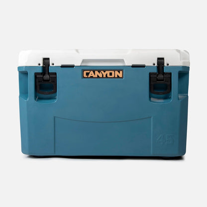The Canyon Coolers PRO Series Cooler, in blue and white with a brown logo and black latches, guarantees maximum ice-retention. It also includes a lifetime warranty for added peace of mind.