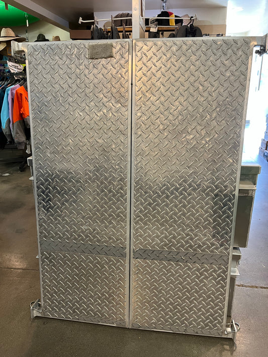 A closed NRS Diamond Plate Cat Floor - Used from NRS, resembling an aluminum cataraft floor, stands on a concrete store floor with clothing racks visible in the background.