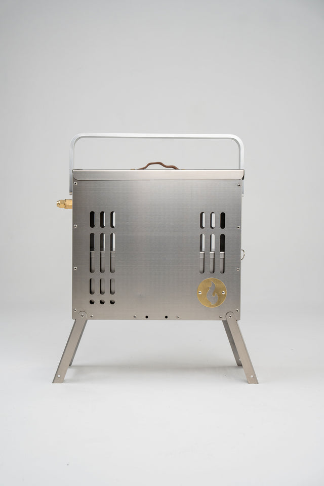 The LavaBox BoomBox Portable Campfire features a stainless steel build, handle, vented sides, brass valve, and foldable legs—delivering a smokeless dual-flame fire pit for campfires anywhere.