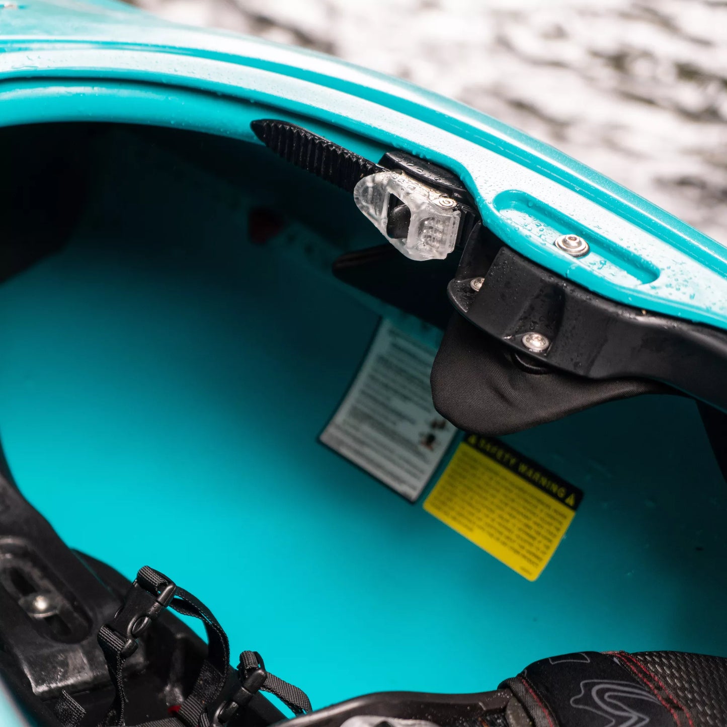 Close-up of a blue Dagger Phantom race kayak's cockpit with foot pedal and safety instructions visible.