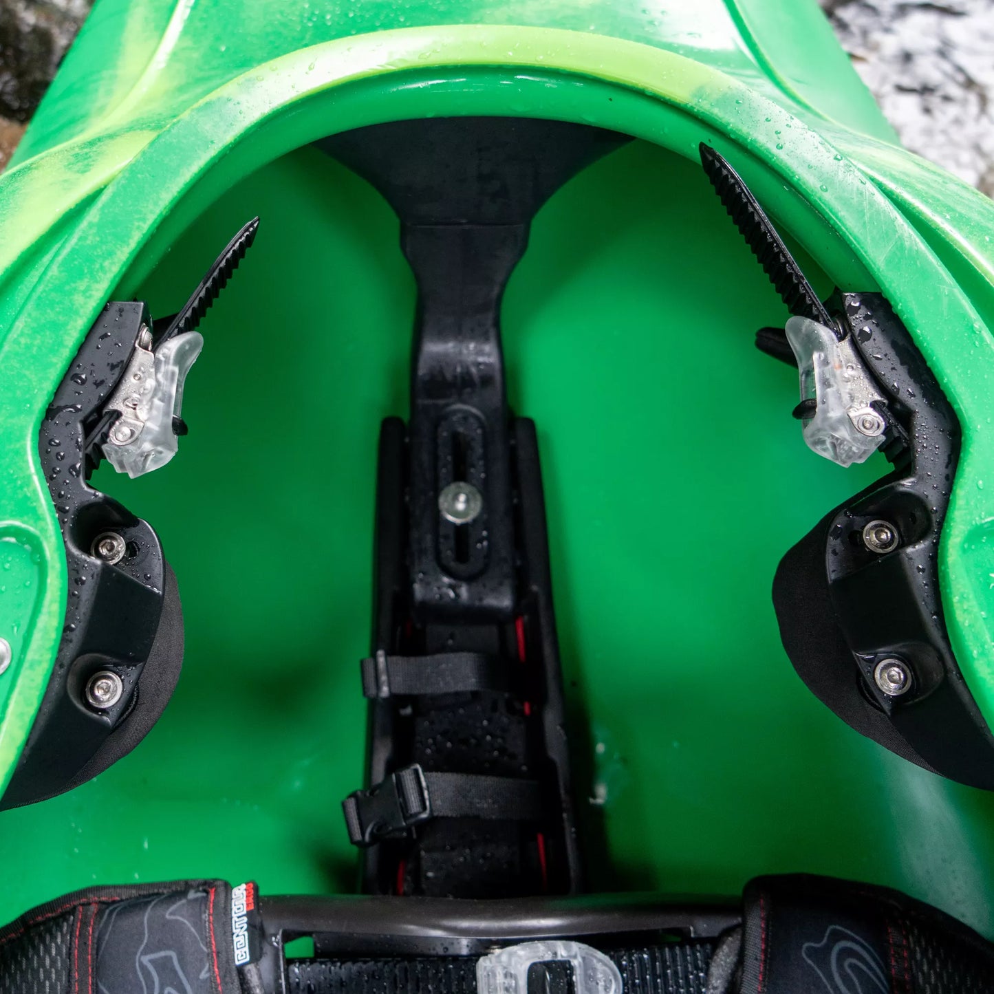 Close-up view of the footrest and thigh braces inside a green Dagger Code Whitewater Kayak.