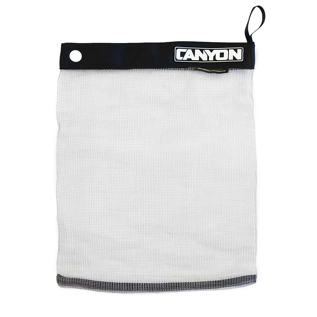 The "Stainless Mesh Drag Bag" by Canyon Coolers is a white mesh gear bag with a black band, secure Velcro seal, and metal eyelet. Ideal for outdoor adventures, "Canyon" is boldly printed on the band.