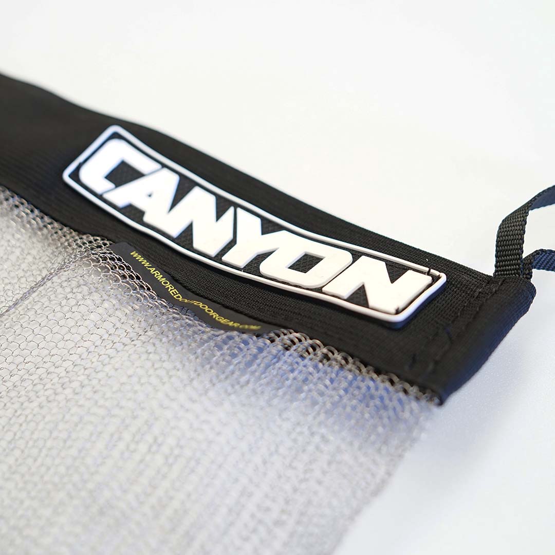 A black Stainless Mesh Drag Bag with the word "Canyon" on it, perfect for outdoor adventures.