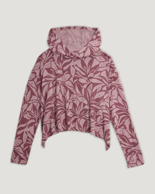 The Women's Bamboo Lightweight Cropped Hoodie by Free Fly features a pink and maroon leaf pattern, asymmetrical hem, loose fit, and UPF 20+ sun protection. Shown laid flat on a white background.