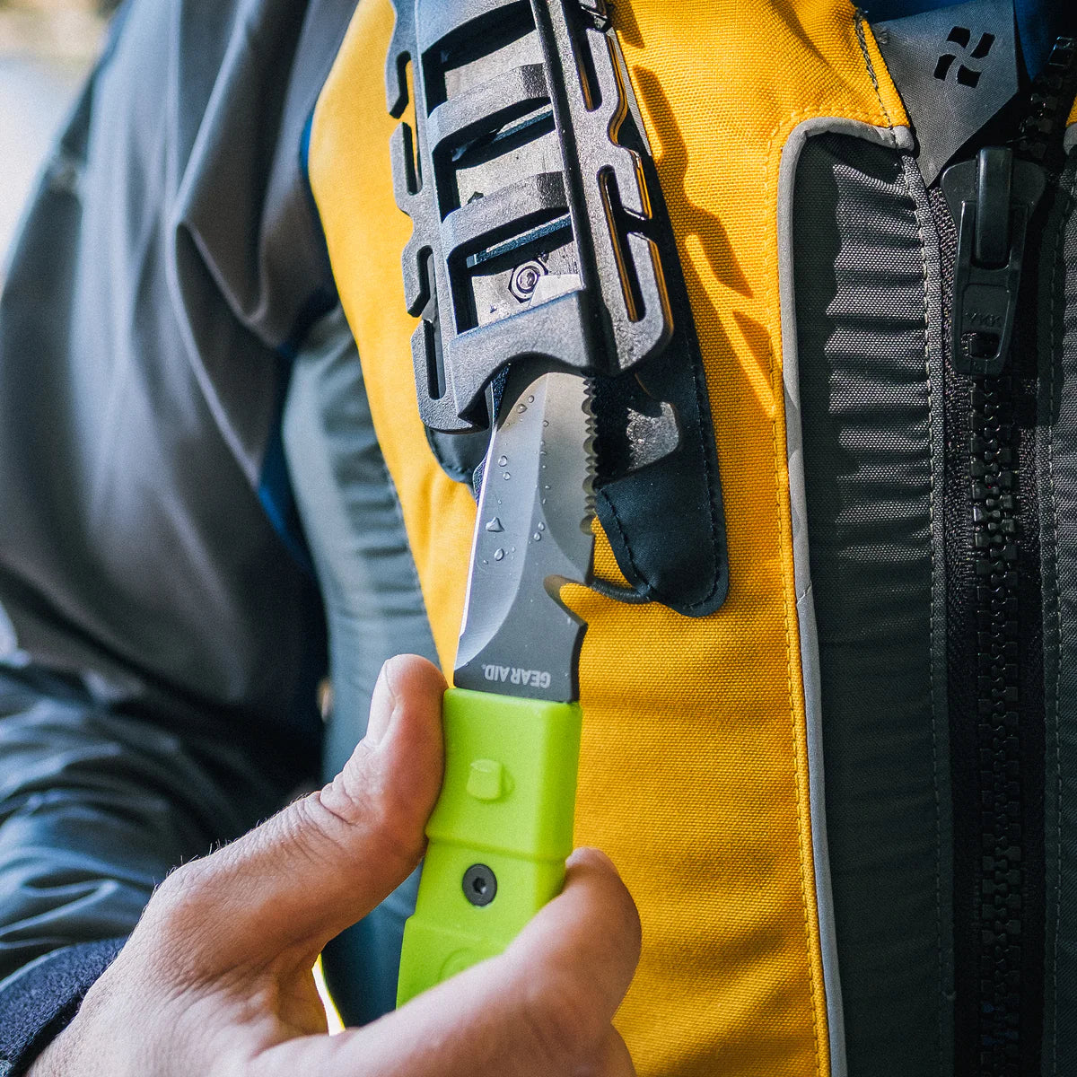 A person equipped with the Gear Aid Akua Knife, ready for freshwater adventures and potential rescue situations, discreetly tucked away in their jacket.