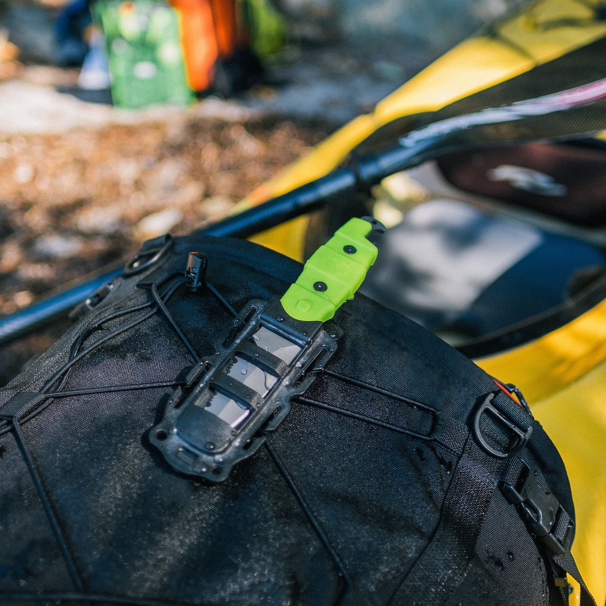 A backpack designed for freshwater adventures, equipped with the versatile and indispensable Gear Aid Akua Knife. This rescue knife is securely attached to the backpack, ensuring readiness for any emergency situations.