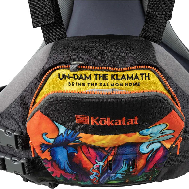 A close-up of a colorful Kokatat Hustle PFD, designed for paddler's mobility, with a message "un-dam the klamath bring the salmon home" printed on.