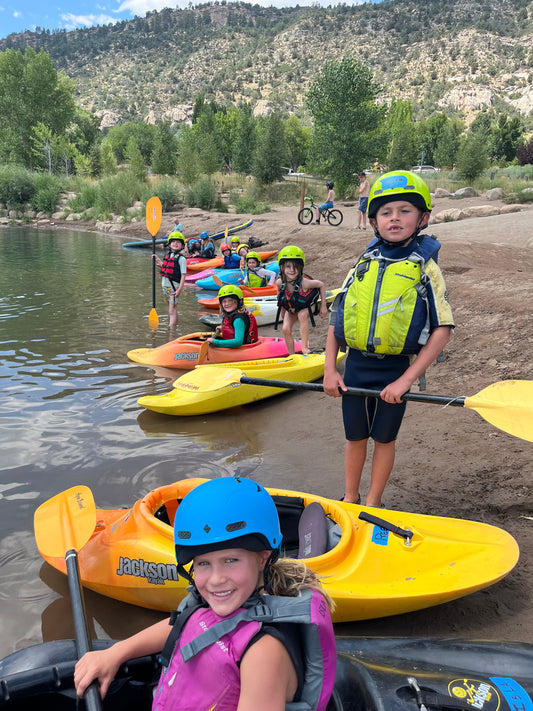 A group of kids enjoying the Tadpole Kayak Class offered by 4CRS Paddle School, kayaking safely together.