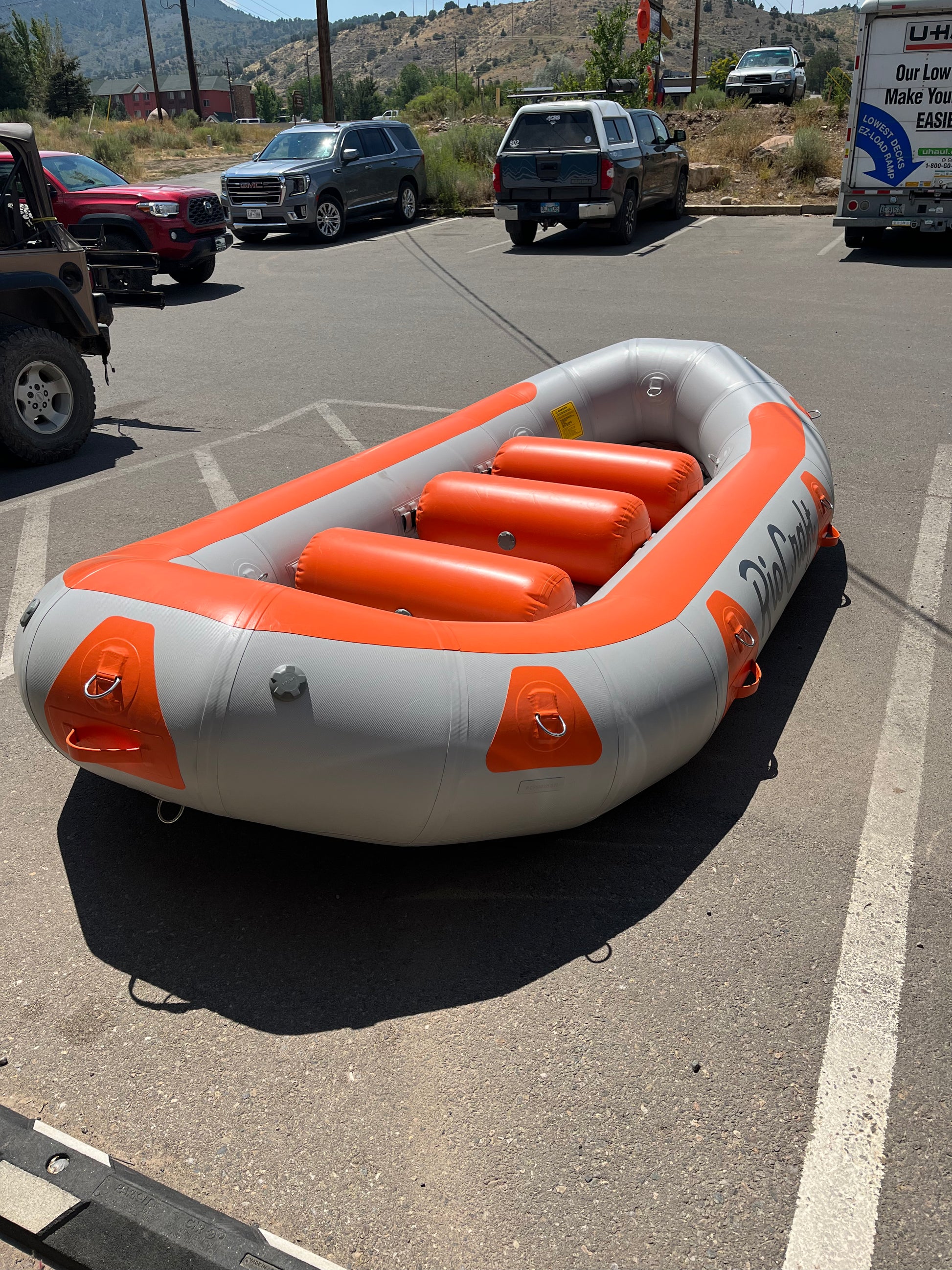 An Consignment 13' Colorado inflatable raft in a parking lot. (Brand Name: Rio Craft)