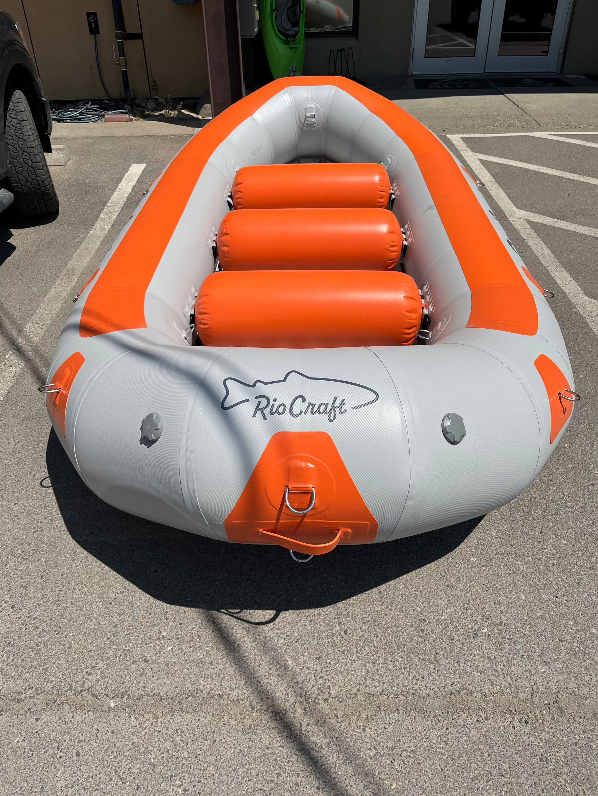 A Rio Craft Consignment 13' Colorado raft parked in a parking lot.