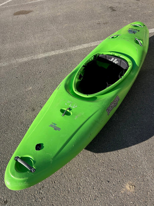 A beginner's Jackson Kayak Karma MD creeker boat sitting in a parking lot.