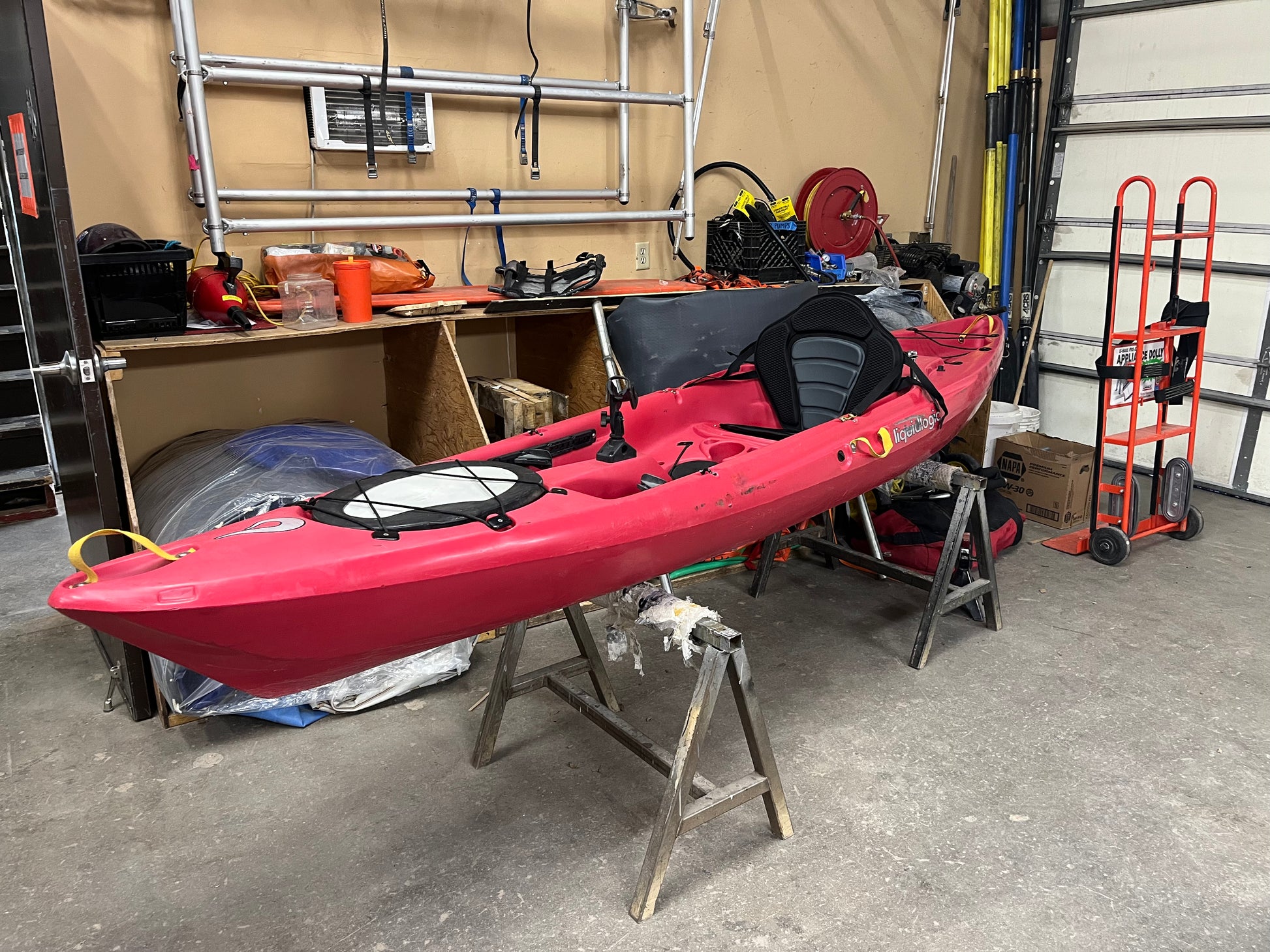 A used Coyote Consignment Manta Ray 12 sit-on-top kayak is sitting in a garage.