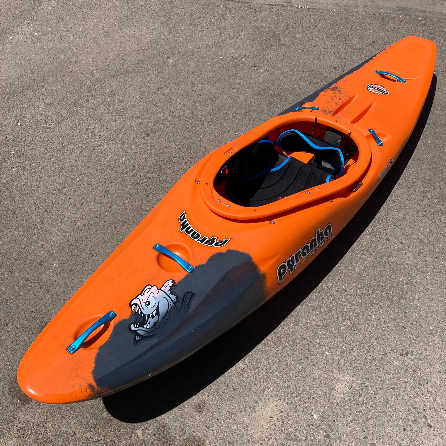 A Consignment Ripper 2 | Small kayak from 4Corners Riversports sitting on top of a parking lot.