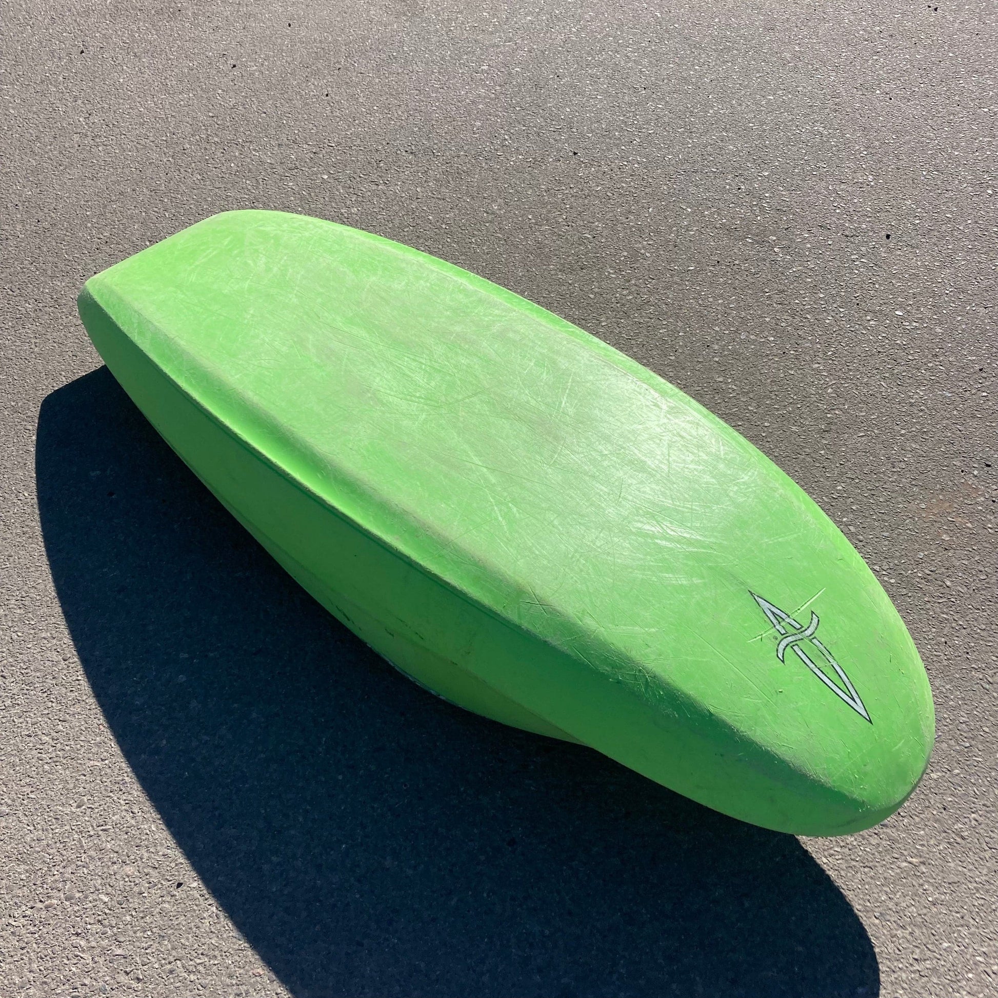 A 4CRS Consignment Jitsu 5.9 surfboard laying on the ground.
