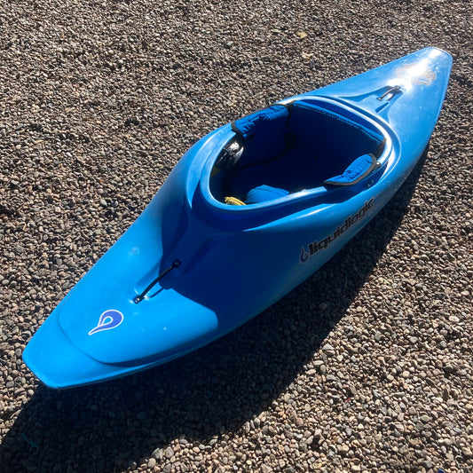A blue Demo Homeslice kayak sitting on gravel. (Brand Name: LiquidLogic)
