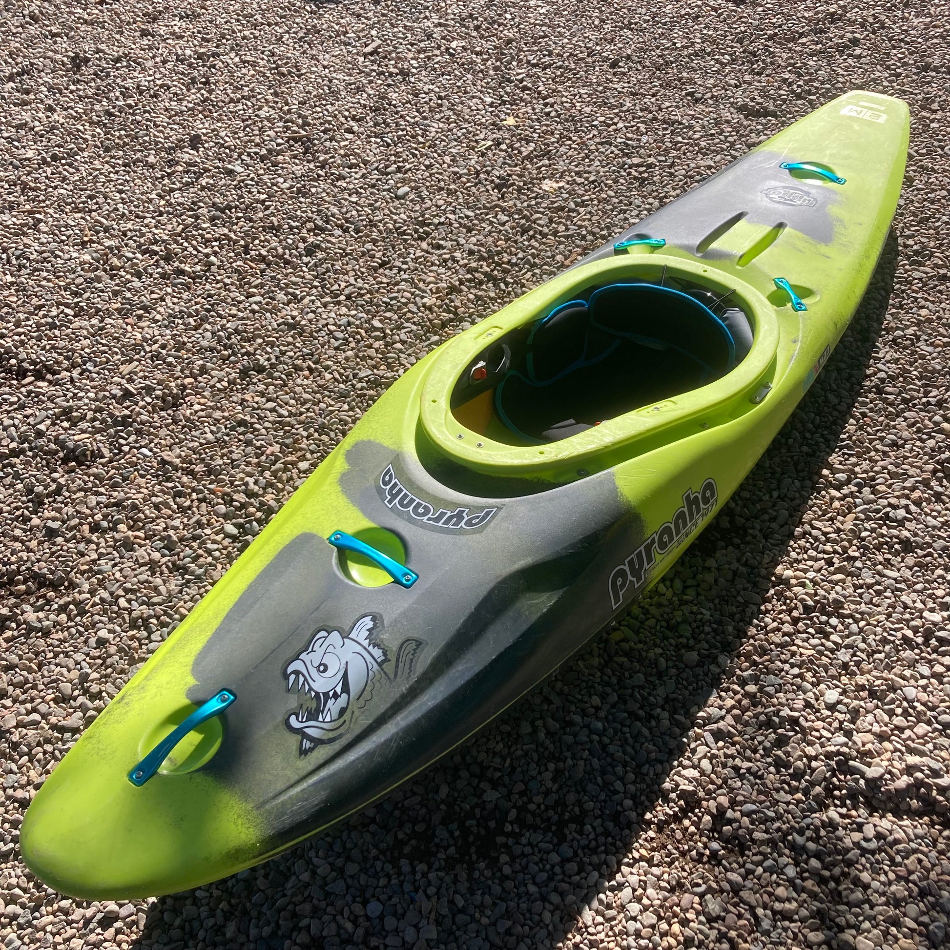 A Demo Ripper 2.0 MD Pyranha kayak laying on the ground.