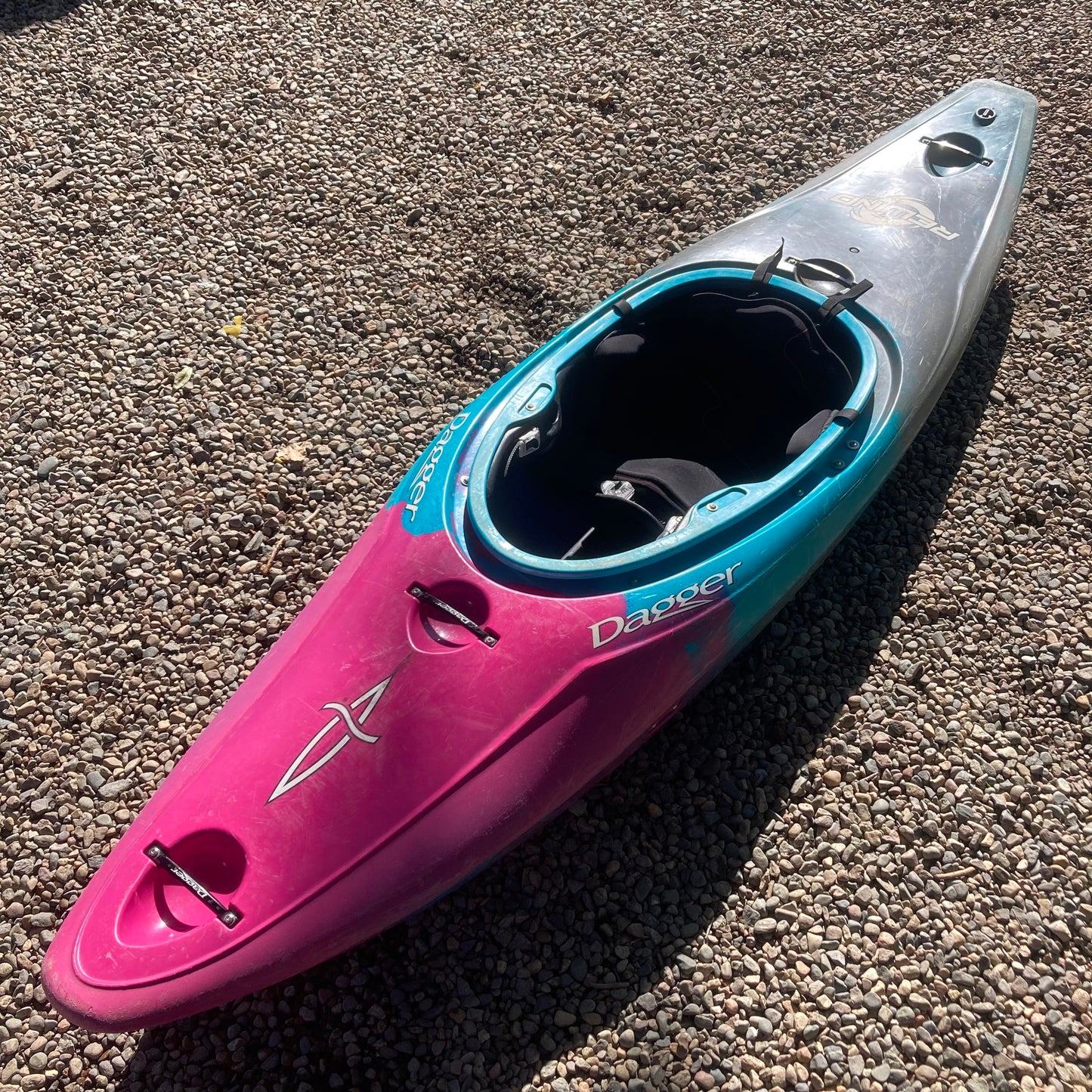 A pink and blue Demo Rewind SM kayak laying on the ground, manufactured by Dagger.