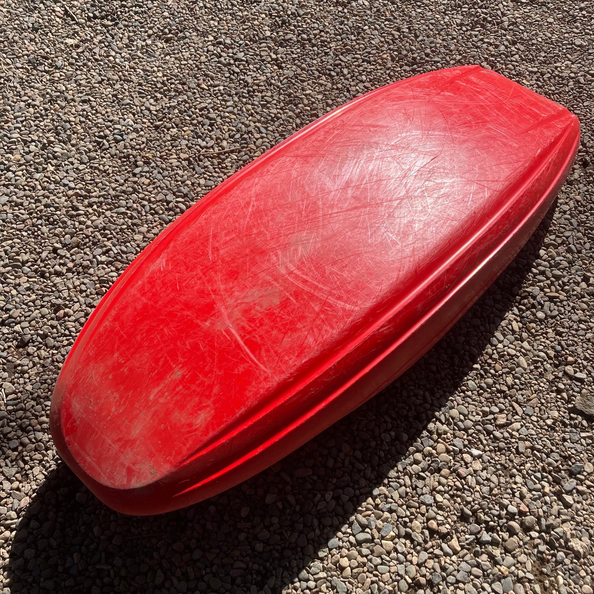 A Demo Rockstar V MD plastic boat laying on the ground. Brand: Jackson Kayak.