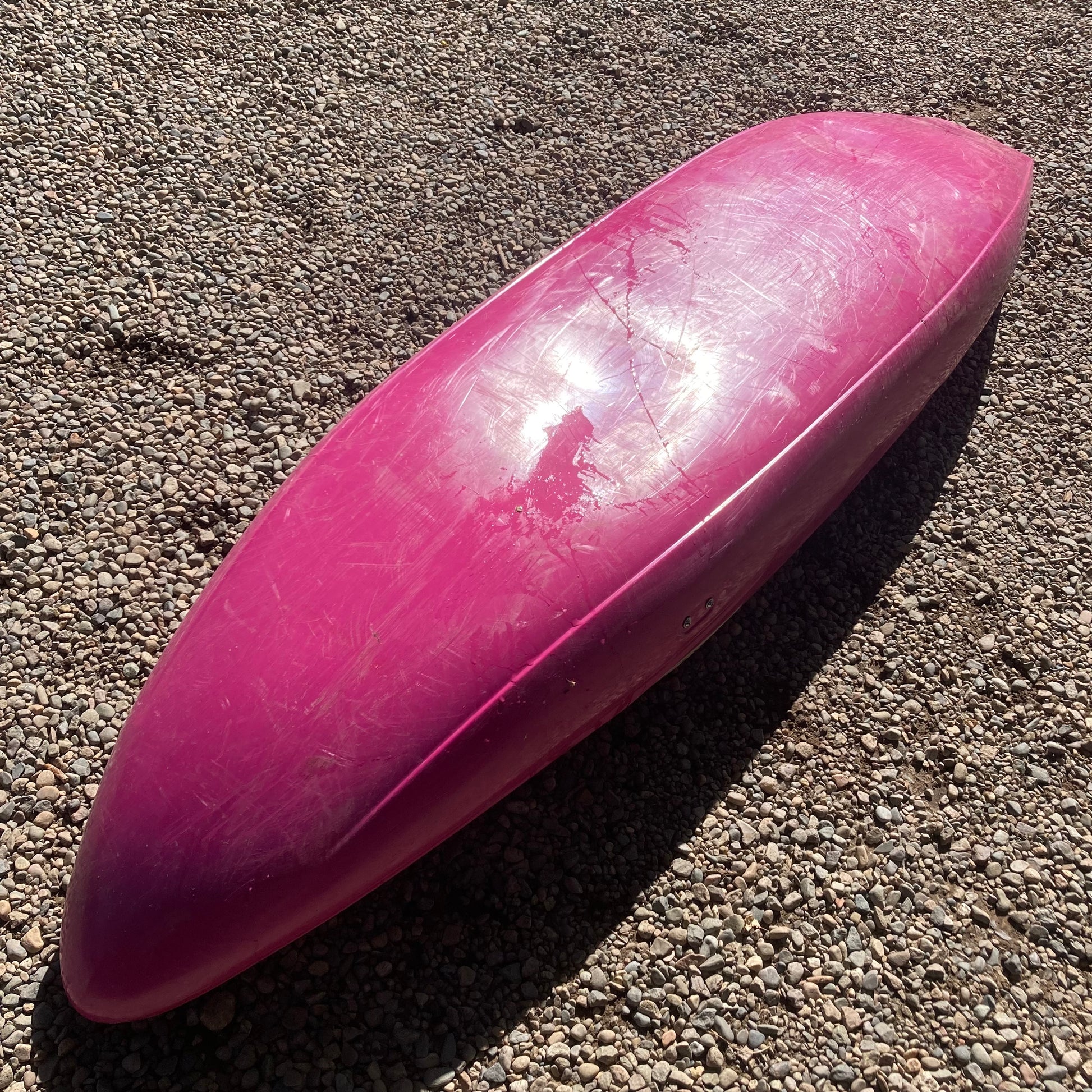 A Verus Demo Flux S/M pink canoe laying on the ground.