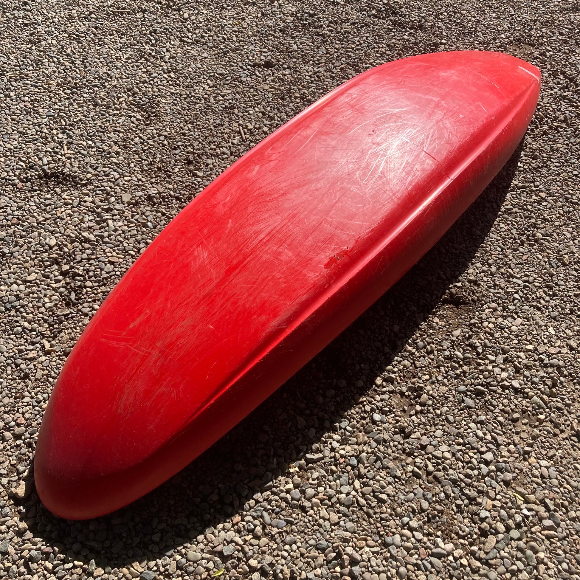 A Demo Gnarvana SM canoe made by Jackson Kayak laying on the ground.