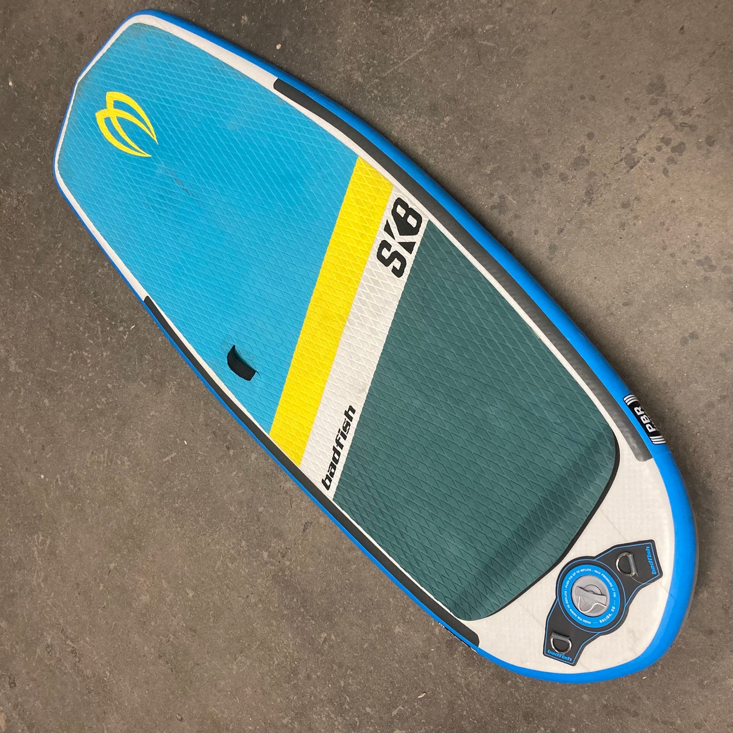 A Badfish Demo ISK8 stand up paddle board on a concrete floor.