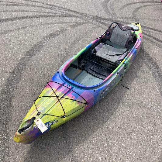 A colorful Jackson Kayak Demo Tripper sitting on a parking lot.