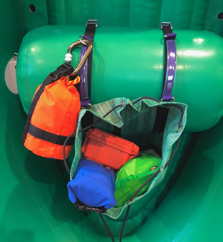 A green inflatable Down River boat with several Thwart Bags in it.