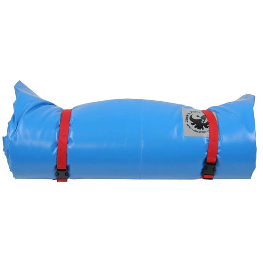 The Super Grande Paco Pad by Jacks Plastic Welding is a blue rolled-up sleeping pad, fastened with two red straps and buckles, featuring a waterproof PVC exterior for enhanced durability.