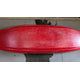 A red Demo Clutch 2025 by Jackson Kayak, showing scratches, is positioned upside down on a concrete surface with visible water stains underneath.