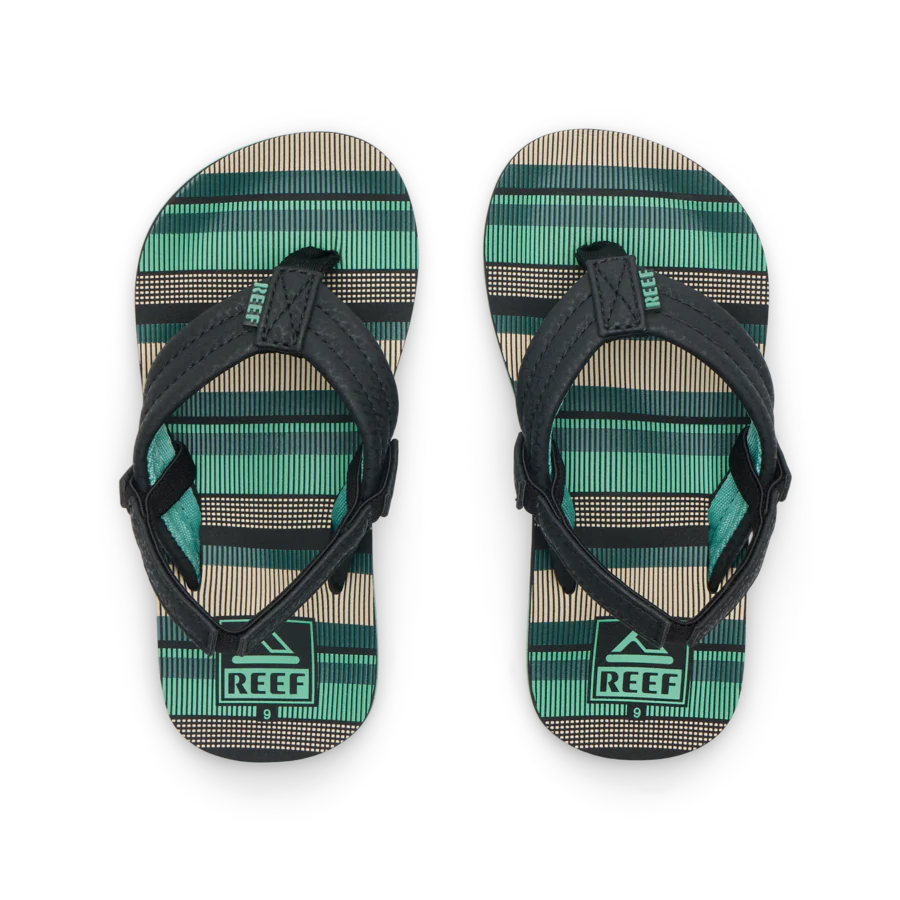The REEF LITTLE AHI Children's Flip Flops feature black straps and green, beige, and black striped soles. Shown side by side, their durable foam outsole provides comfort—ideal kids’ sandals for daily wear.