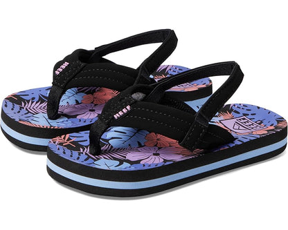 REEF LITTLE AHI Children's Flip Flops for kids with black straps, a blue, purple, and pink floral-patterned sole, blue-striped platform base, and durable foam outsole.