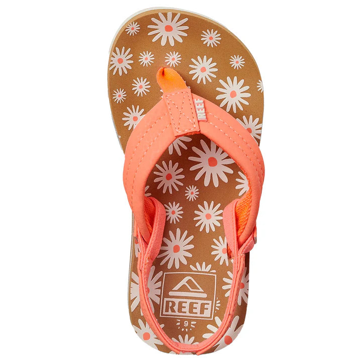 Top view of REEF LITTLE AHI Children's Flip Flops featuring a pink strap, brown sole with white and pink daisy patterns, and a durable foam outsole for comfort and style.