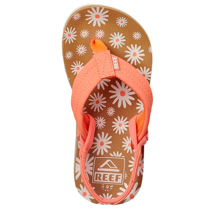 Top view of REEF LITTLE AHI Children's Flip Flops featuring a pink strap, brown sole with white and pink daisy patterns, and a durable foam outsole for comfort and style.