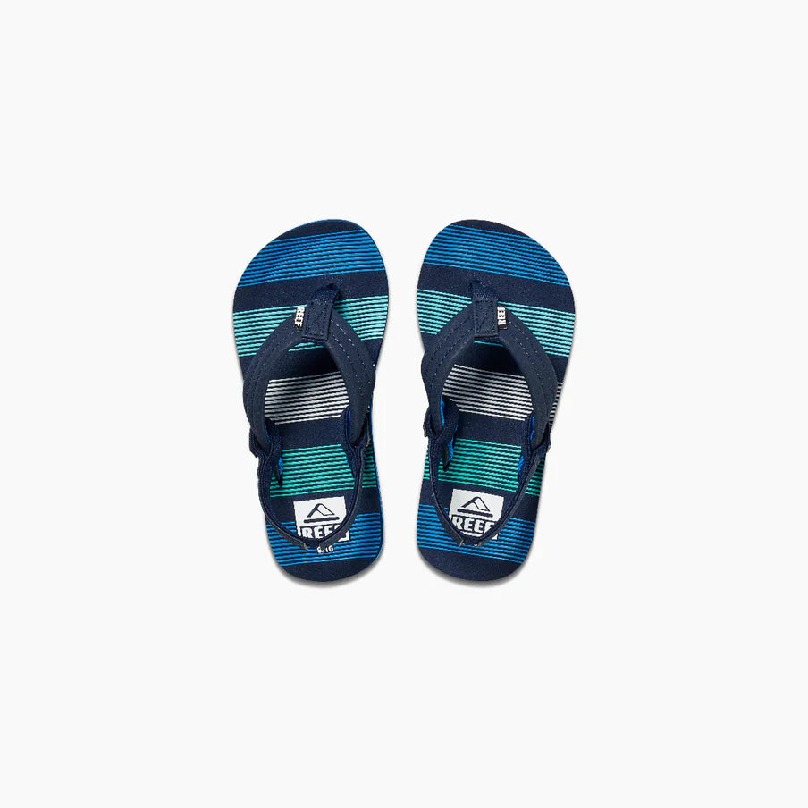 The REEF LITTLE AHI Children's Flip Flops feature navy blue straps and blue, teal, and white striped soles, with the Reef logo on the footbeds and a durable foam outsole for all-day comfort.