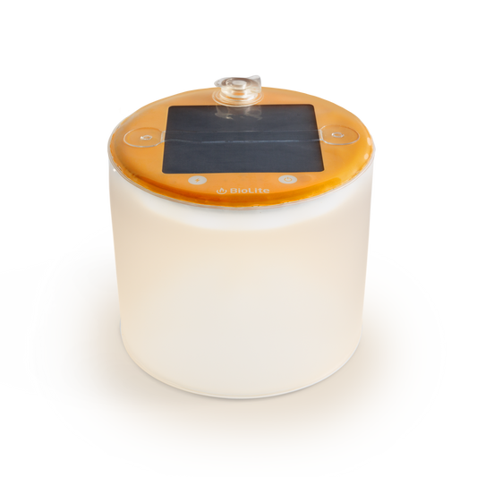 The BioLite Luci Original Matte is a cylindrical rechargeable lantern with a translucent white body, orange top, solar panel, and control buttons—ideal as a waterproof camping light for portable outdoor lighting.